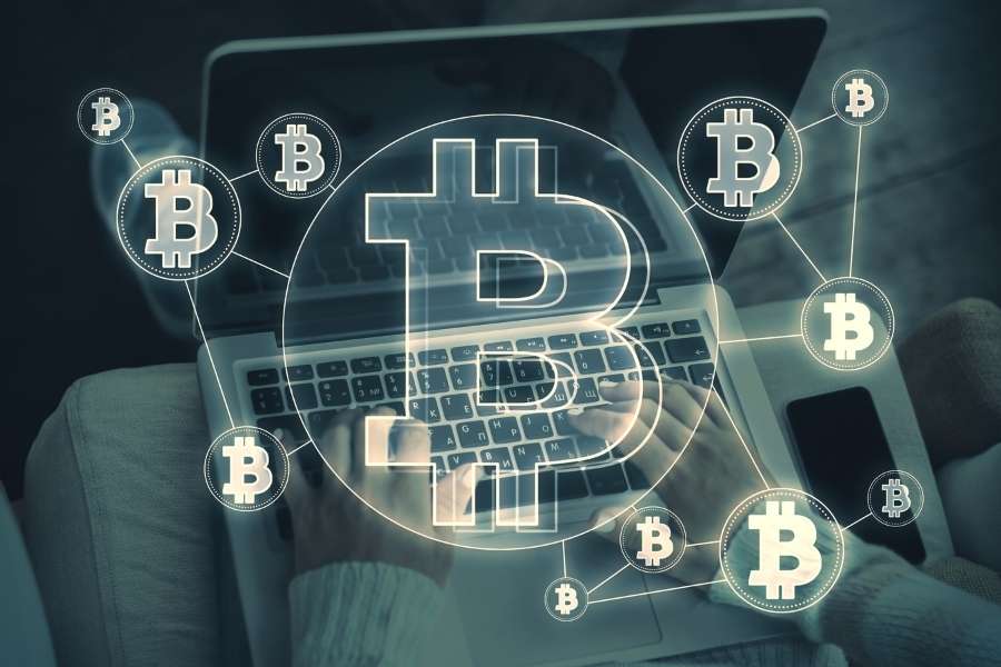 Une personne utilise un ordinateur portable pour surveiller ses gains en cryptomonnaie grâce à une interface Bitcoin interactive.